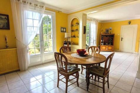 Salle à manger lumineuse avec des murs jaunes, une