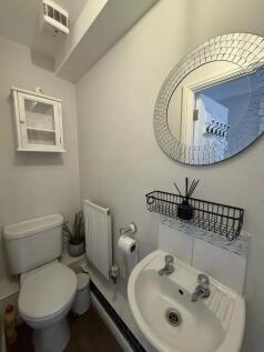 Clean and stylish toilet with mirror and sink...