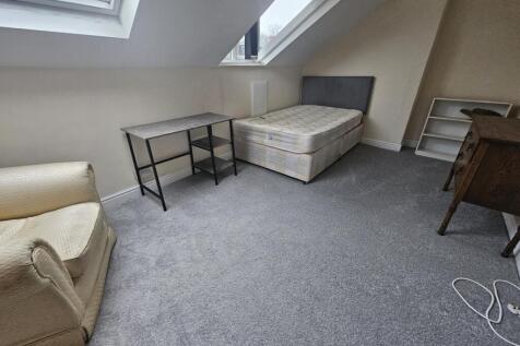 Bright attic bedroom with a double bed, skyligh...