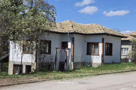 White house with tiled roof and wooden windows in village Dolets