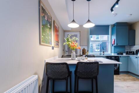 Stylish blue kitchen with a modern breakfast ba...