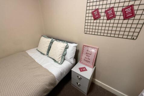 Cozy single bedroom with a neatly made bed, neu...