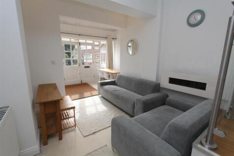 Bright lounge with plush grey sofas and storage...