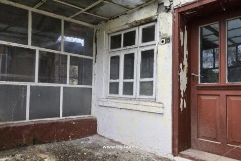 Covered porch showing window and wooden door with peeling paint