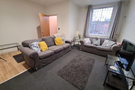 A spacious, well-lit living room featuring comf...