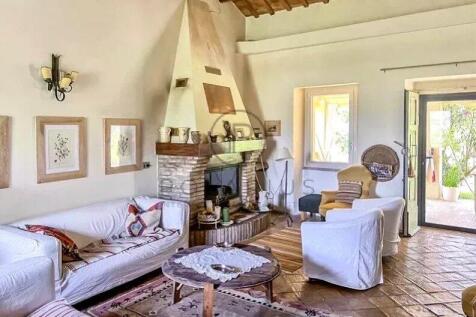 Cozy living room with white sofas, a brick firepla