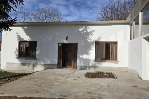 Main entrance area featuring a glass door and two windows on white walls