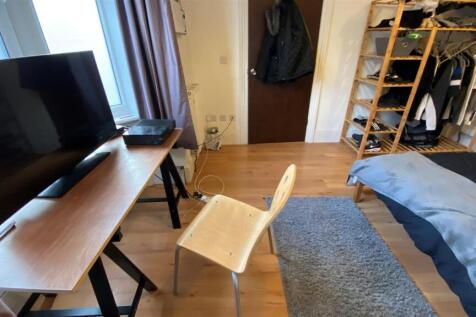 Bright bedroom with wooden desk and storage....