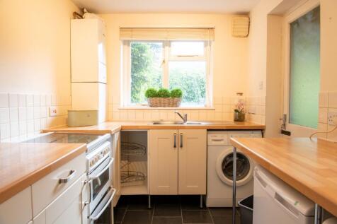 Bright galley-style kitchen with wooden worktop...