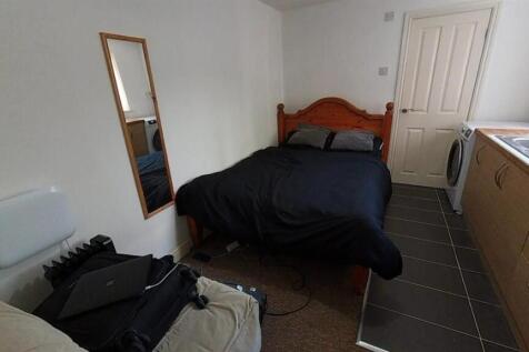Practical studio space with comfortable bed...