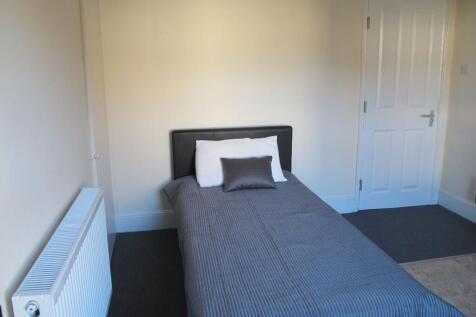 Neat single bedroom with a simple upholstered h...