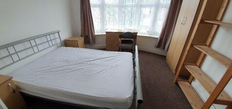 Bright master bedroom with large desk and stora...