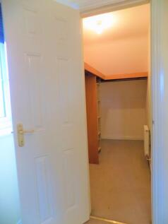 A small, tidy storage room with built-in shelvi...