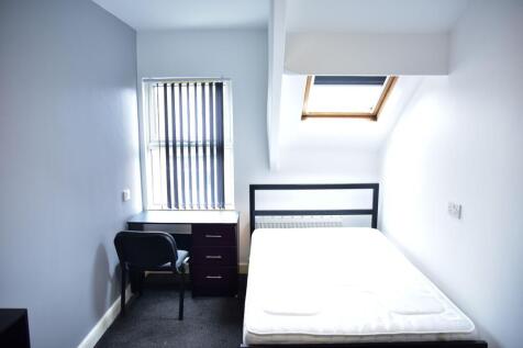 A bright and tidy bedroom featuring a comfortab...