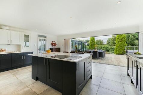 Chef's kitchen opening to scenic dining terrace