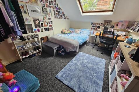 A spacious and inviting bedroom featuring a lar...