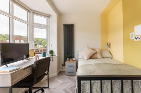 Bright bedroom with bay window and study desk s...