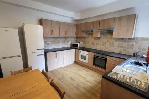 Bright modern kitchen with light wood cabinets,...