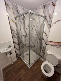 A modern bathroom featuring a stylish corner sh...