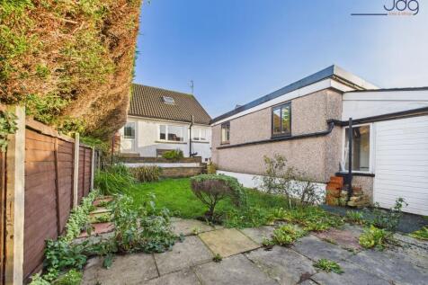 A mixture of flag and lawn garden with garage and workshop access