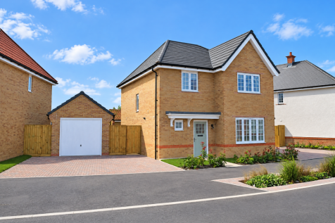 A modern two-story brick house with a detached garage and paved driveway sits under a bright blue sk