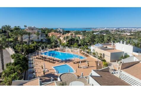 Aerial view of resort townhouse with swimming pool and sea views in Ferragudo, Algarve.