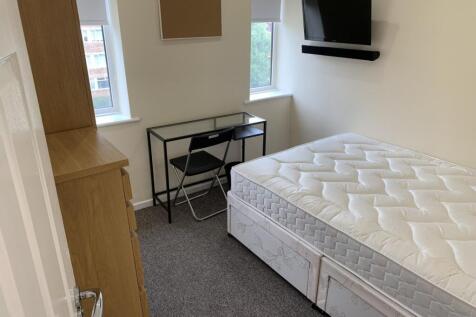 A bright and tidy double bedroom featuring a de...