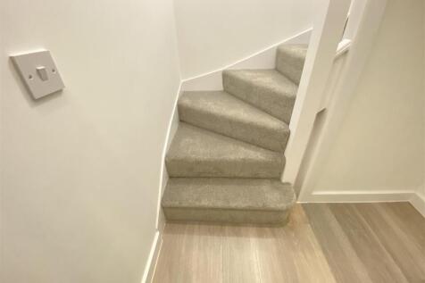 Modern plush carpeted stairs and wood flooring...