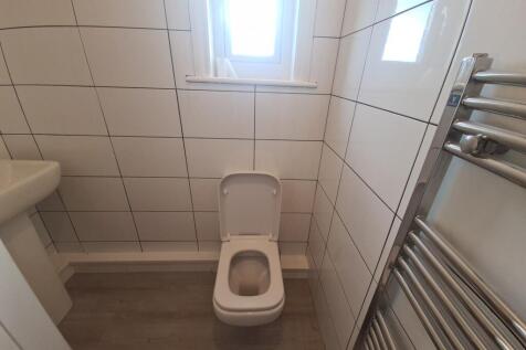 Neat tiled bathroom with a modern toilet, chrom...