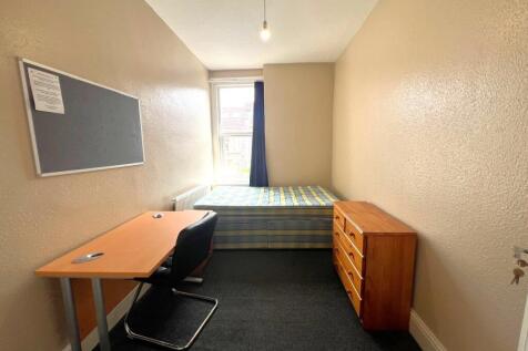 Neat single bedroom with a study desk, comforta...