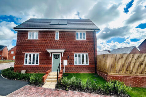 A modern red brick house with a light blue door stands in the foreground