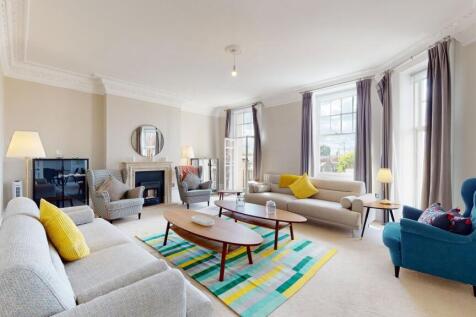Bright and spacious living room with large wind...