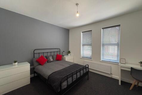 Bright, modern double bedroom with a metal-fram...