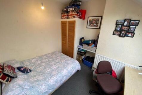 A cozy single bedroom with a neatly made bed, d...