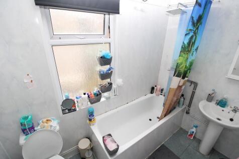 Bright bathroom with a full bathtub and window....