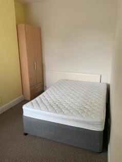 Bright, simply furnished bedroom with a double ...