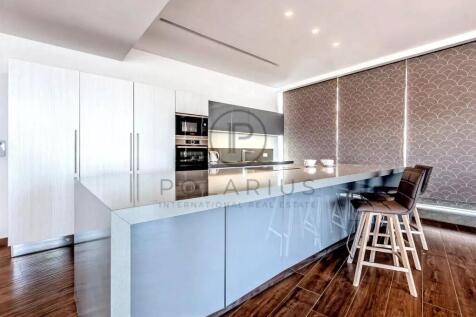 Modern kitchen with a sleek island, barstools, con