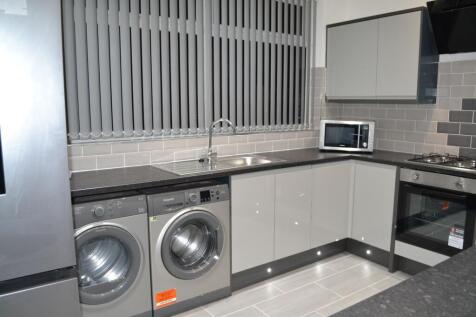 Modern fitted kitchen with grey gloss cabinets,...