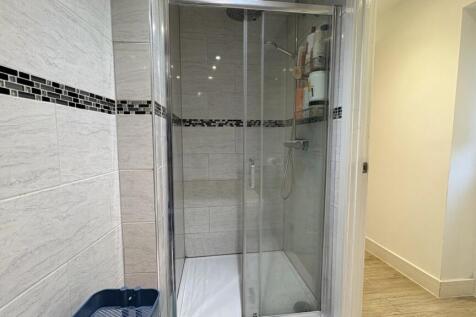 Modern bathroom with a glass-enclosed shower, t...