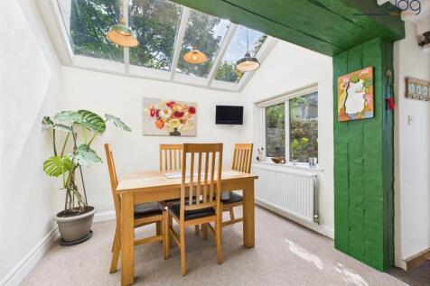Light-filled dining area beneath a vaulted glass roof