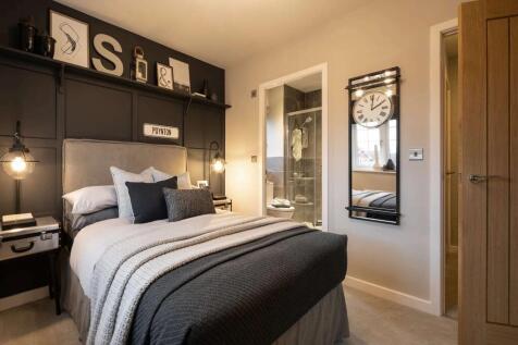 A cozy and stylish bedroom with a dark-colored bed frame, plush bedding