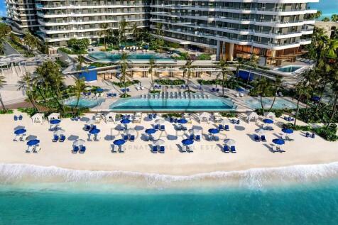 A beachfront resort with blue umbrellas and lounge