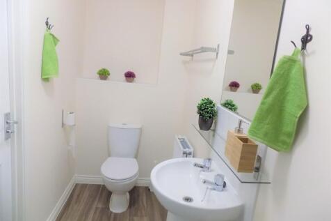 Bright, modern bathroom with clean white sanita...