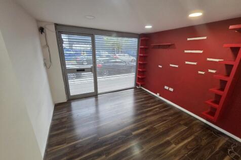 Modern entrance with wood flooring and red deco...