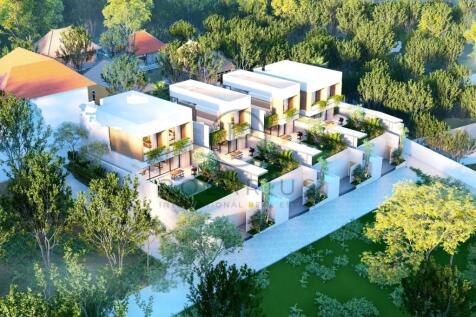 Aerial view of a modern, white-roofed residential 