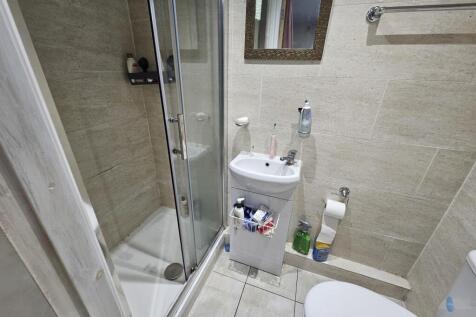 A modern, clean bathroom featuring a glass-encl...