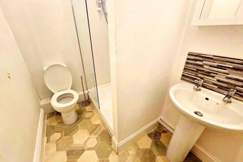 Compact, clean bathroom with a pedestal sink, t...