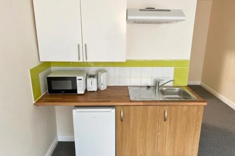 Bright kitchen with lime tiles and wood finishi...