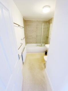 Bright, modern bathroom with a tiled shower-ove...