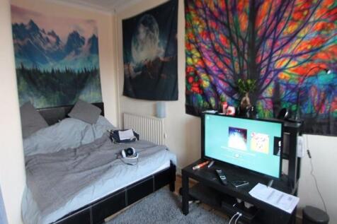 A spacious master bedroom featuring a large bed...